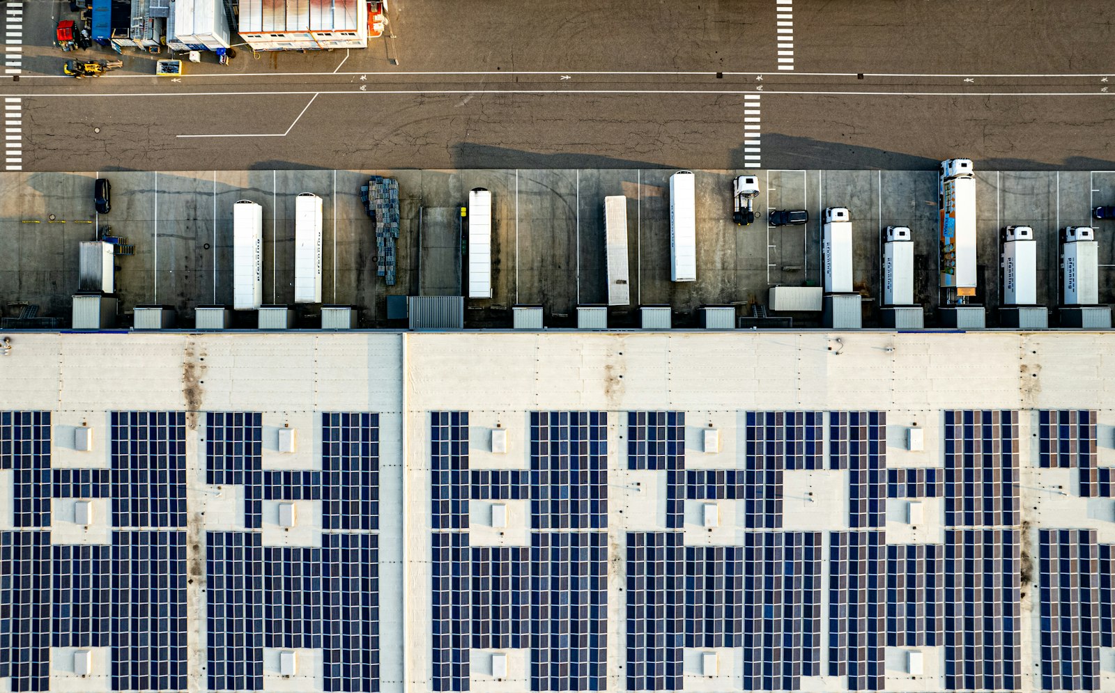 Aerial view of a business warehouse with solar panels covering the roof